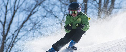 gutt med hjelp som kjører slalom. foto. 